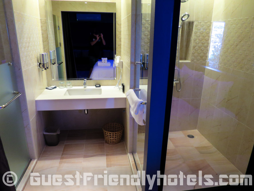Bathroom has the sink in the middle with shower and toilet on each side in Tweet Tweet Nest Pattaya Hotel