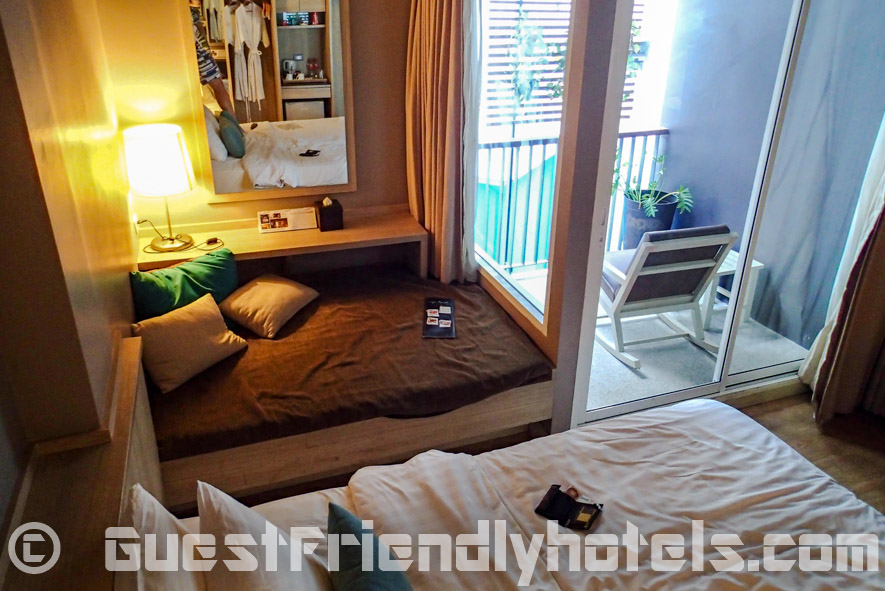 Deluxe rooms have a small balcony and a place to sit on the side of the bed in Aya Boutique Hotel Pattaya