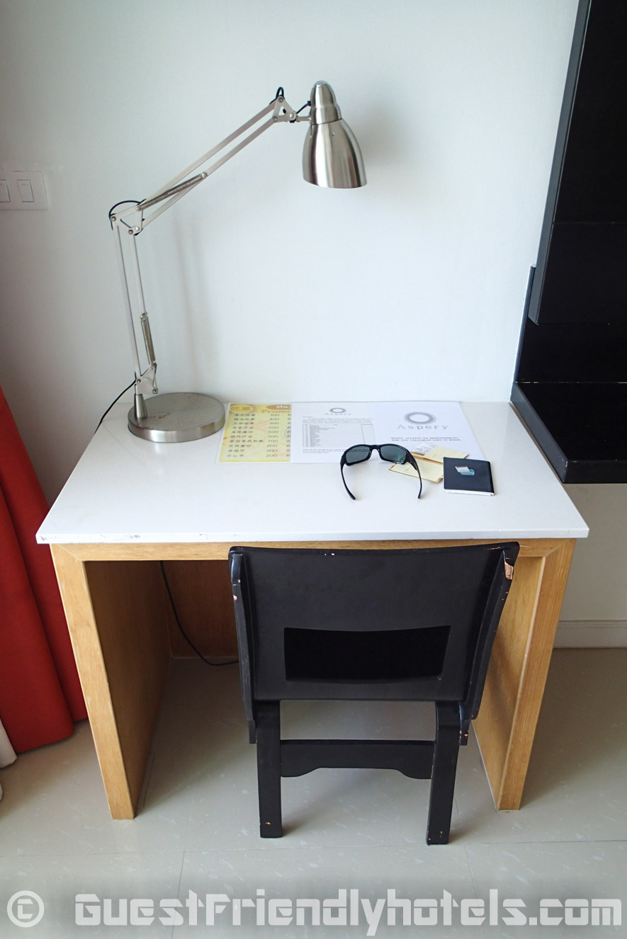 Small desk and chair next to the TV in Aspery Hotel room